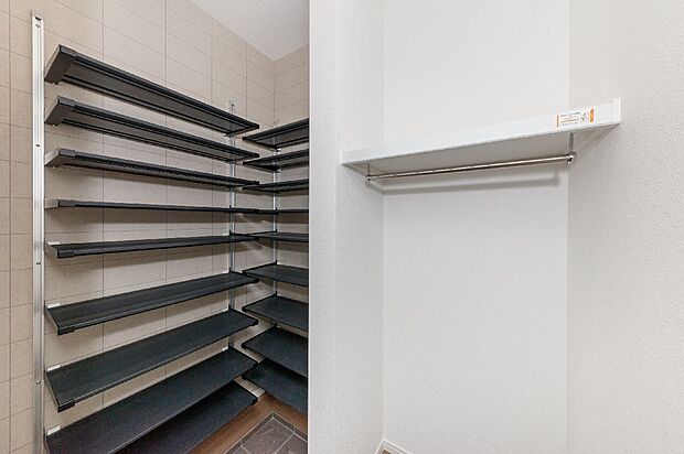 【【19号棟/玄関】】大容量の土間収納にはハンガーパイプや可動棚を設け機能的な収納スペースに。土足のままで出入りができ、靴だけでなくアウターや雨具、ベビーカーなどのお出掛け用品をまとめて保管いただけます。