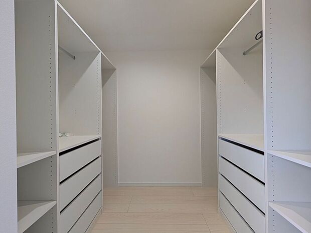 【【2号地】ウォークインクローゼット】システム収納付のウォークインクローゼットは衣服や小物をすっきりと整理することができます。鏡を設置しても中で着替えられる十分な広さがあるため、プライベートも守られる設計です。