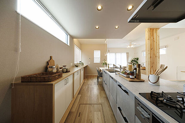 【モデルハウス2号棟】キッチンの天井に意匠性の高い間接照明を設え洗練されたLDKを演出しました。キッチン背面に収納スペースの棚を設置しました。※2号棟/2025年4月撮影