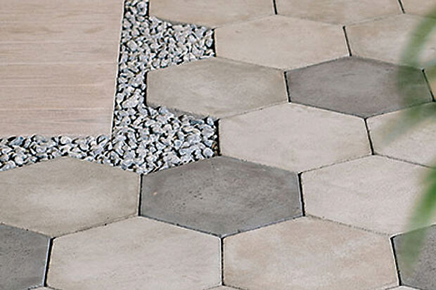 【【ニュートペイブ ヘキサ】】直線的なデザインが多い外構に、新たな表情を添える六角形の舗装材「ニュートペイブ ヘキサ」を採用。ダイナミックなリズムを演出し、単調になりがちな庭空間をモダナイズし個性的なアクセントを付加。まるでアート