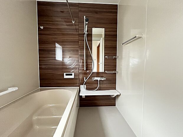 【【7号棟　一日の終わりにくつろげる浴室】】ブラウンのアクセントパネルが、落ち着いた雰囲気を演出する浴室です。ゆったりとした浴槽は、しっかりと肩まで浸かることができ、一日の疲れを穏やかにほぐします。