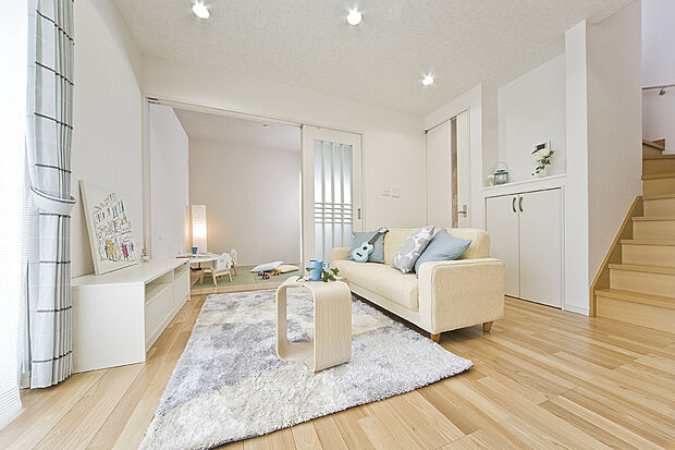 【【当社施工例】LDK】フローリングの木目が柔らかな印象を与えるリビング。ナチュラルテイストの家具がよく合います。隣接している和室は、客間やプレイルームとしても活用いただけます。