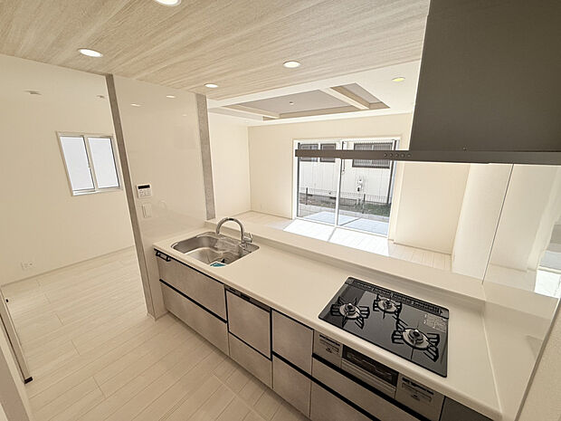 【【(1)号棟　キッチン】】家事負担を軽減する食器洗乾燥機付きのキッチンです。カウンター下部の収納は、スライドオープンタイプのため、奥のものまで簡単に取り出すことができます。便利な床下収納も設けています。