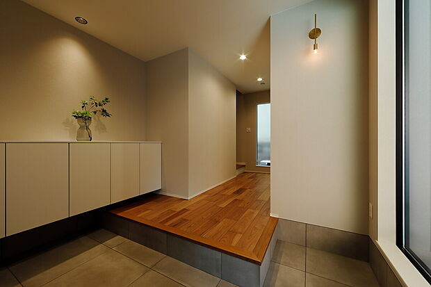 【【木のぬくもり感じるナチュラルモダンな家】】その家の顔となる玄関は、ゆとりのある広さを確保し、スポット照明でライトアップ。限られた土地面積でも、間取りの工夫や空間の取り合い方で、実際の面積以上の広さが感じられます。