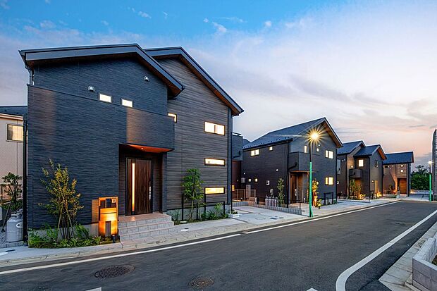 【建物プラン例 (外観写真)】【施工例住協建設】黒の木目調が織りなす重厚な佇まい。 洗練されたダークトーンの質感が夕暮れの街並みに美しく映える、デザイン性の高いモダン邸宅。