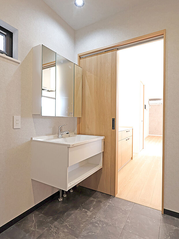 【【１２蓮池１号地】キッチン～洗面室】フロートタイプの洗面ドレッサーを設置した洗面室は、キッチンと玄関からの２wayで帰宅時の手洗いなどにも便利な配置。
