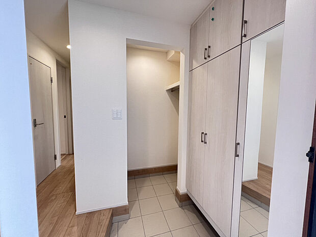 【玄関土間収納】　雨の日のレインコートや来客時の上着をかけるのに便利な枕棚を設置した玄関土間収納。お子様のベビーカー置きなど多様な活用が出来ます。