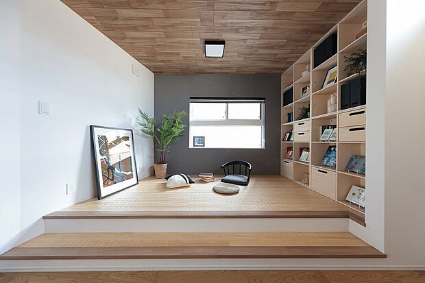 【【本棚と心地よい床のあるステージ】】フロアレベルを一段上げ、掘り机と本棚を設えたステージリビング。そばにいる家族の気配を感じながら、仕事や勉強に集中できます。※モデルハウス1号棟