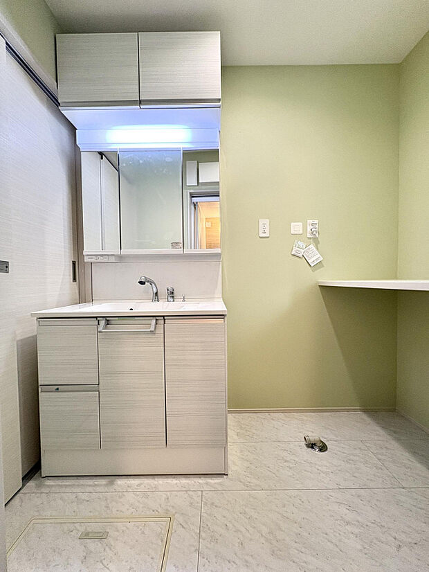 【【2号棟/洗面所】】吊戸棚付きの洗面化粧台とカウンターを設けた洗面所。洗濯やアイロンがけ、畳む作業まで一ヶ所で完結できます。