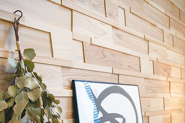 【【無垢材アクセント壁パネル「木もれ美」】】厚みや幅の異なる国産杉材を貼り合わせた、独特の手触りや素材感を感じる壁装飾パネルをリビングの一部に採用。木が持つリラックス効果や無垢材ならではの調湿効果と風合いが居心地の良い空間を創出します。※色は号