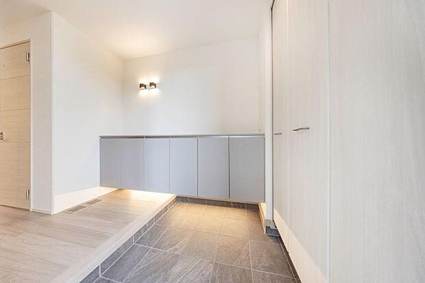 【No.4_玄関（撮影_2025年10月）】ゆとりのある玄関スペースに幅が広く収納力がある玄関収納。間接照明の落ち着いた雰囲気も兼ね備えたお出迎え玄関です。