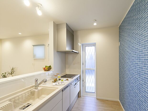 【当社施工例】リビングやキッズリビングにいるご家族の様子が見渡せる開放的な対面キッチンを採用。勝手口からは明るい光も入り、調理中にも家族とのコミュニケーションが弾むプランです。