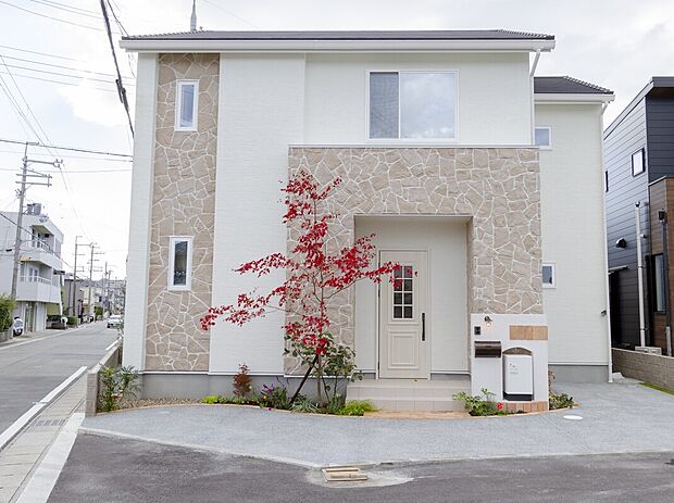 【【当社施工例】】柔らかな色合いの石目がアクセントとなる外観です。玄関ドアや門柱等も欧風デザインでトータルコーディネート。お手入れがしやすいサイズの植栽を設けることで、四季折々の自然を感じさせてくれます。