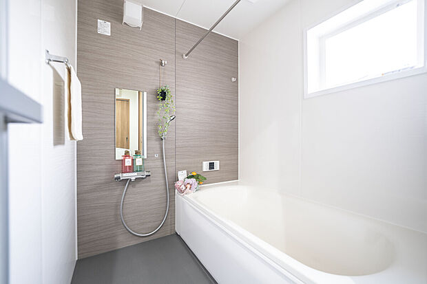 【【1階浴室/B号地】】アクセントパネルや洗い場のカラーがやわらかな雰囲気のバスルーム。足を伸ばしてリラックスでき、洗い場はカウンターレスで広々としています。高い位置の窓は開閉でき、自然換気も叶います。