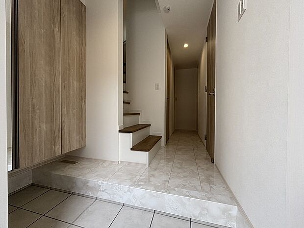 施工例　扉を開けた瞬間、目の前に広がる大理石調のフローリングがエントランスに一層の輝きと開放感を演出