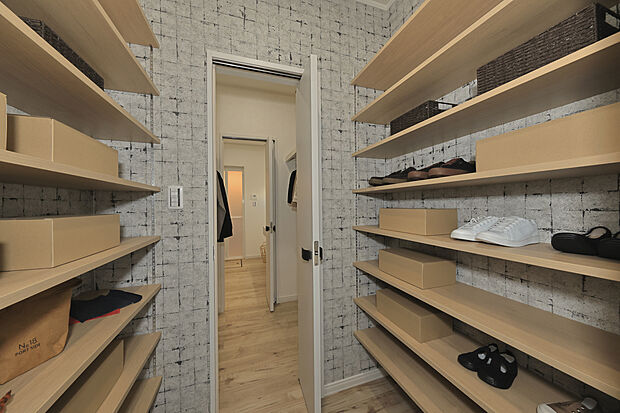 【モデルハウス写真(8号地)】
玄関には大容量のシューズクロークを造作しました。可動棚付きで、たくさんの靴や小物を仕舞えます。洗面室へと繋がり、帰宅後のスムーズな手洗い動線が叶います。