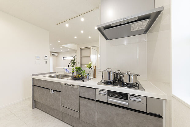 【【キッチン/当社施工例】】高級感漂うグレーのシステムキッチンを採用。すっきりとした印象の整流板付きレンジフードやビルトイン食洗機を搭載し、機能性にもこだわりました。