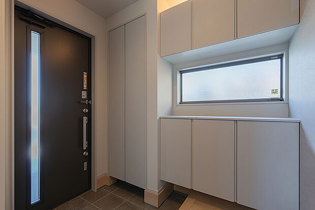 【玄関(2号棟)】落ち着いた雰囲気を演出する間接照明付きの玄関。家族や来客を心地よく迎えます