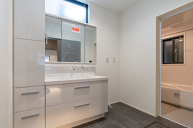 【洗面室(1号棟)】白を基調とした爽やかな洗面室。大容量の収納を備えています。