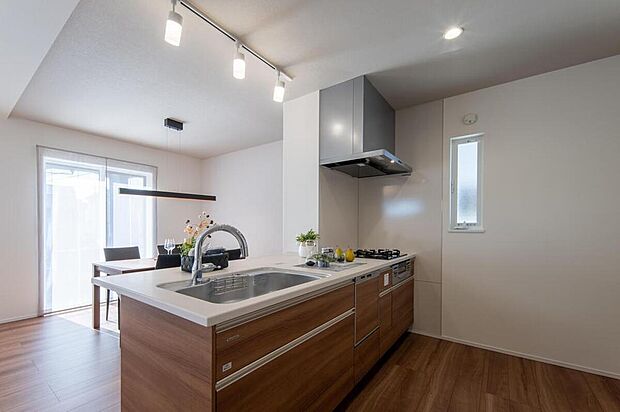 【施工例/キッチン】
調理中もご家族との会話が弾む、対面式キッチン。木目調×白のワークトップでまとめた、スタイリッシュなデザインです。タッチレス水栓や食洗機など、機能も充実しています。