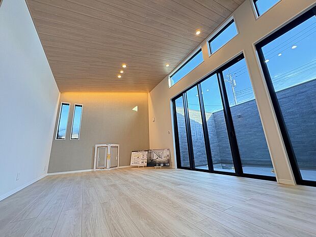 【吹き抜けLDK・中庭側】大開口サッシから中庭へとつながるLDK。勾配天井と間接照明が、開放感と落ち着きを両立させます。