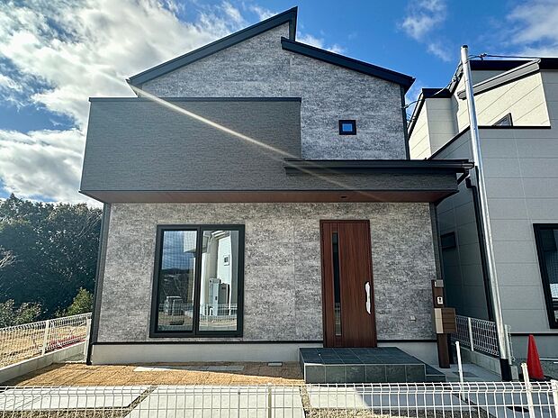 【24号地外観】重厚感のあるブラックとグレーの外観が魅力の24号地。ドアの木目がアクセントになった、コンセプトハウスです。プライバシーが確立され、お庭でのプールなどを楽しみたい方におすすめです。