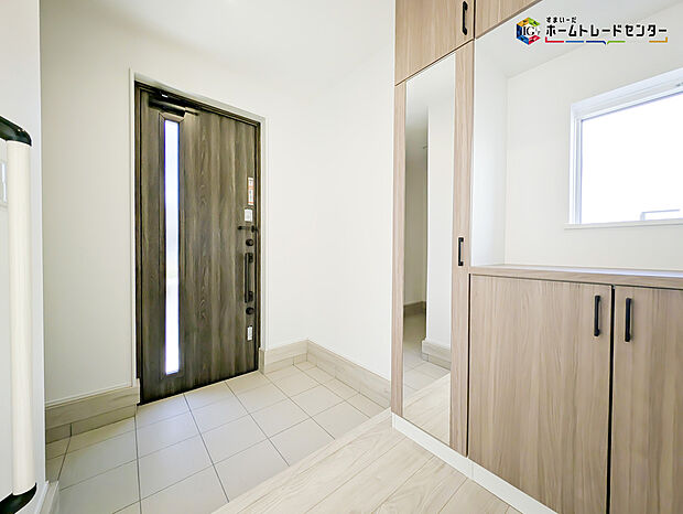 【玄関】明るく清潔感のある玄関でお客様を迎えるスペースをパッと明るい印象に！大容量の収納力で大家族の履物もすっきり収納できます♪ウッドテイストの玄関ドアがお洒落です。