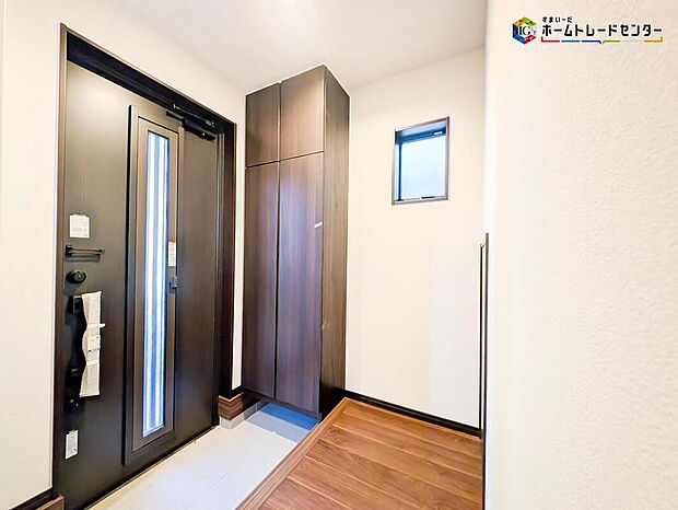 【玄関】明るく清潔感のある窓付きの玄関でお客様を迎えるスペースをパッと明るい印象に！大容量の収納力で大家族の履物もすっきり収納できます♪ウッドテイストの玄関ドアがお洒落です。