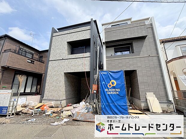 外観画像：3階建ての2棟が並ぶ外観。各棟に専用カースペースとバルコニーを備え、モダンな色合いが前面道路に調和し、落ち着いた住まいの雰囲気を感じられます。周辺に馴染む落ち着いた佇まいです。