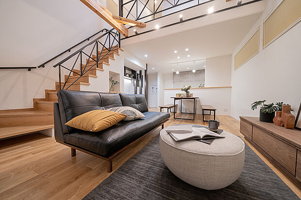 当社施工例：木造の梁・間接照明・吹き抜けの大空間を彩ります。階段をアイアン手すりにすることで開放感を演出。階段下にスタディースペースを配置。子供達がリビングでも集中して勉強できるように設計しました