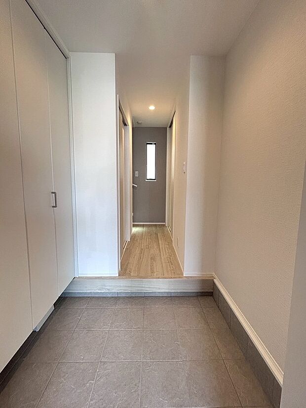 【【1階玄関】】ホワイトカラーでまとめられ、正面の窓から爽やかな風が届き、やわらかな自然光を反射する明るいエントランス。グレーのクロスにより奥行きが感じられ、落ち着いた印象です。