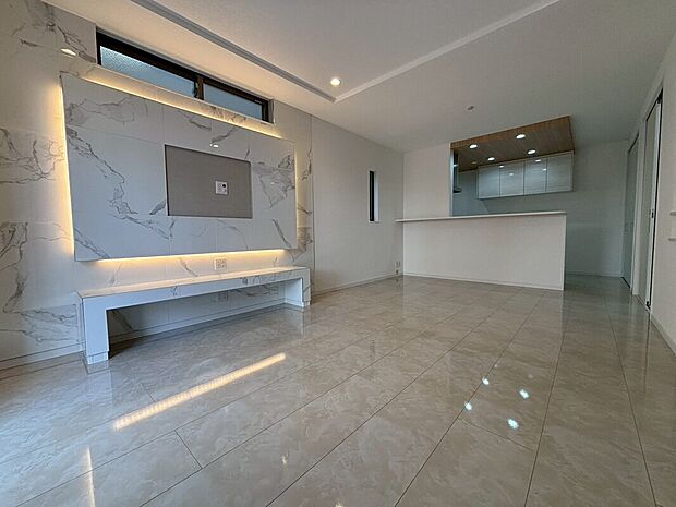 【【1階約16.5帖LDK/1号地】】LDKはキッチン、ダイニング、リビングを直線に配置したI型です。建築工事が順調に進み、光沢感ある大理石調の壁面ボードや折上天井など、上質なデザインで特別感ある空間に。