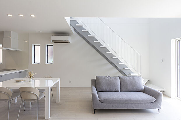 【1階約18帖LDK/A号地モデルハウス】吹抜からの光が心地よく、ホワイトを基調としたホテルライクなLDK。オープン階段はモダンで美しいデザインに。光を遮らず明るく開放感のあるリビングを実現しました。