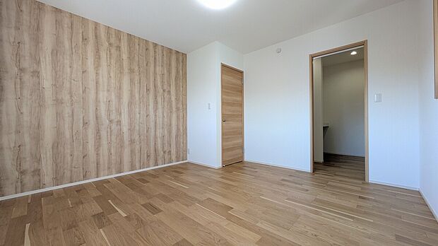 【NO.3　主寝室】木目のアクセントクロスが印象的な主寝室。落ち着きのある色合いで、リラックスできる空間に仕上げています。（2026年1月撮影）