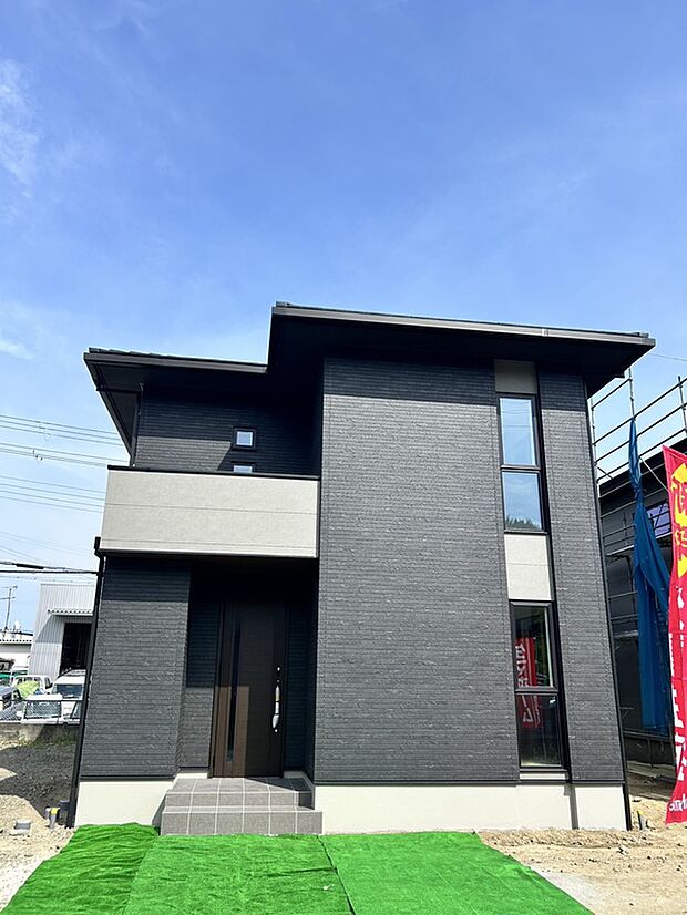 【【1号地】建物完成!】重厚感のあるダークトーンの外観が目を引く、洗練されたデザイン住宅。縦長の窓がスタイリッシュな印象を演出。