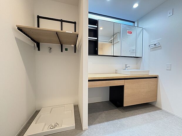 【洗面室】
ナチュラルな雰囲気でお洒落な洗面室です。洗面ボウル横のカウンターが広いので、身支度も快適に行えます。洗濯機置き場の上部に、収納棚が設置されています。