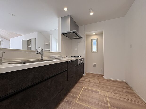 【キッチン/2号棟】ご家族とコミュニケーションを取りやすい、対面式キッチンが採用されています。リビング・ダイニングで過ごすお子様を見守りながら調理可能です。