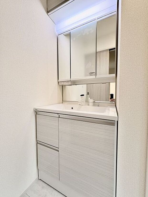 【【洗面室】】2階に配置されています。洗面化粧台は、身支度の際に重宝する三面鏡+ミドルミラー付き。鏡裏とボウル下に収納があり、洗剤類や掃除用具の整頓に役立ちます。