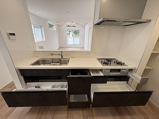 【【キッチン/1号棟】】グリル付きの3口コンロで、複数調理が同時に可能です。シンクやコンロ下には収納が備わっており、作業スペースを広く確保できます。