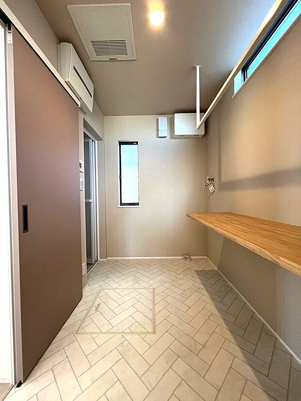 【ランドリールーム】浴室そばにあるランドリールームです。キッチンと繋がっていますので家事しながらのお洗濯がとても楽です。部屋干しの可能です。カウンターをつけていますので色々便利に使えます。