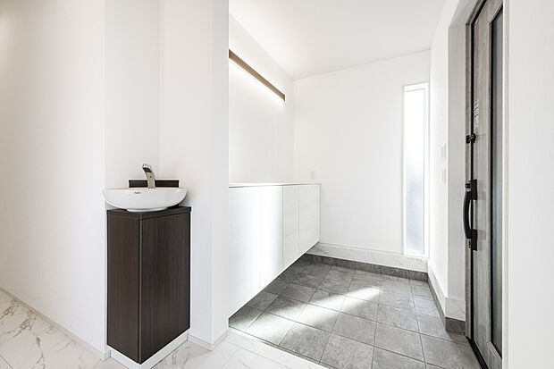 【玄関脇の洗面コーナー施工例】玄関脇に設けた洗面コーナーの施工例。帰宅後すぐに手洗い・うがいができる動線を確保し、住まいの清潔さをスマートに保ちます。来客時にも使いやすく、生活感を抑えながら機能性を高めた設計です。