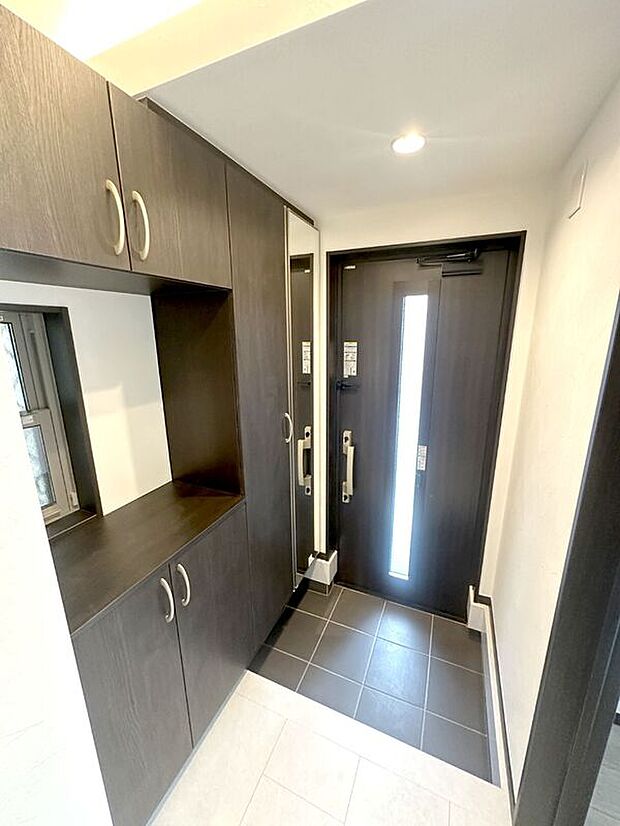 【玄関】大容量のトールタイプの玄関収納つき。姿見付きですのでお出かけ前のチェックにも便利。【Ａ号棟　2025年7月撮影】