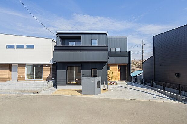 【2号棟（ASOBUとMANABU）イメージ】ネオブラックのガルバリウム外壁。艶感と、細いピッチの凹凸が立体感を演出。ブラックでも重くならず、クールで洗練された印象です。