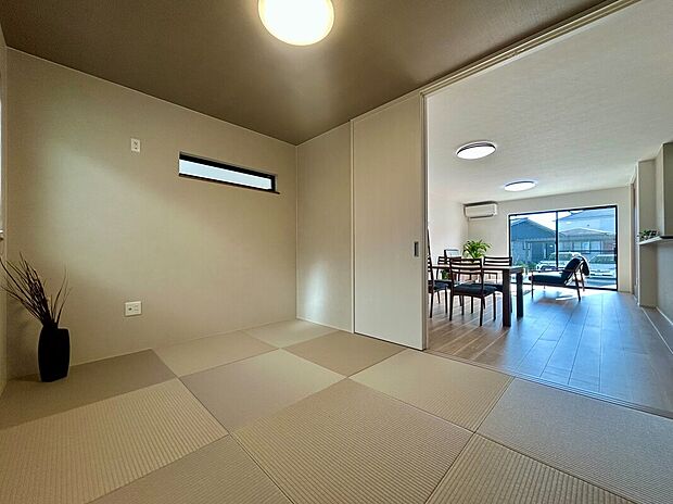 【【A-7棟 和室】】リビング・ダイニングから繋がる6.0帖の和室は半帖畳やプリーツスクリーンを活用し、和風モダンなデザインです。洗濯物を畳んだり、アイロン掛けをしたりなど家事スペースとしても活躍します。