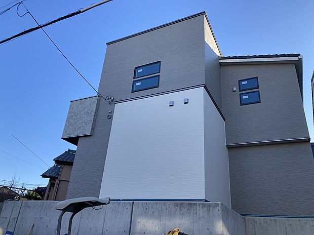 【【B棟　外観】】周辺の街並みと調和する、お洒落な外観デザイン。アースカラーの優しい色合いが青空に映えます。全棟長期優良住宅認定物件です。