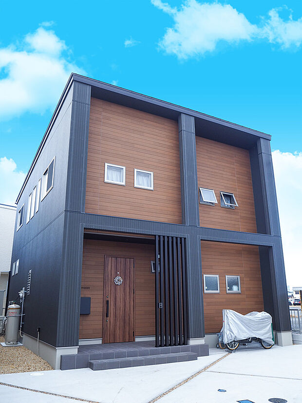 【【施工例】外観】ダーク系と自然系で分譲地内でもひと際目立つ存在感を放つ外観デザインとなっています。