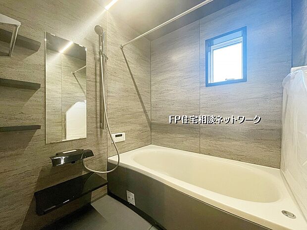 【浴室】落ち着いた石目調のパネルが高級感を演出するバスルーム。ゆったり浸かれる広めの浴槽で一日の疲れをリセット。窓付きで換気もしやすい快適空間です。