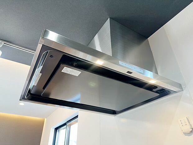 【レンジフード】スタイリッシュなレンジフードを採用したキッチン。手元を照らす照明付きで調理中も見やすく、お手入れもしやすい設計です。