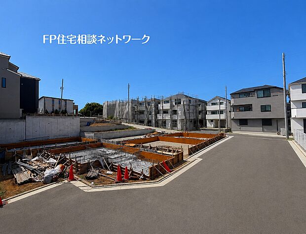 【前面道路含む現地写真】周辺の建物や足場が組まれた建築現場の様子です。新しい住宅が多く立ち並ぶ活気あるエリアで、工事も順調に進められています。