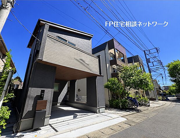 【前面道路含む現地写真】【外観】  木目調とダークカラーを組み合わせた、落ち着きのある外観デザイン。道路側に設けたバルコニーが建物に立体感を添え、軒天の木目が住まいの表情を美しく引き立てています。